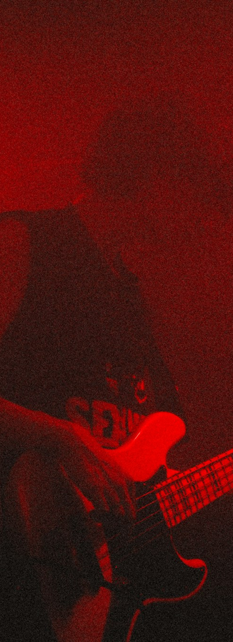 Musician performing under red stage lighting